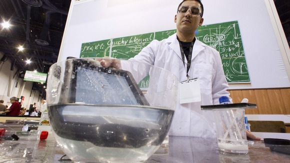 An iPad takes a dip into a bowl of water at the LifeProof booth at the CES