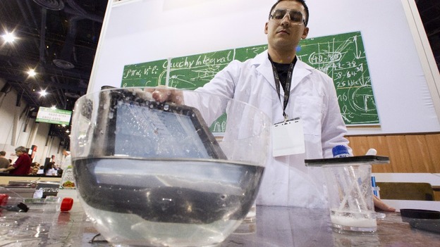 An iPad takes a dip into a bowl of water at the LifeProof booth at the CES