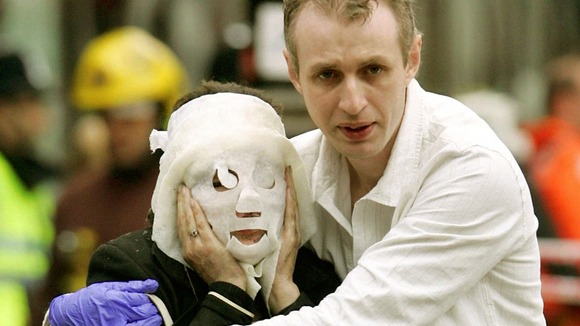 A wounded woman is guided from Edgware Road tube after the July 7 attacks in 2005