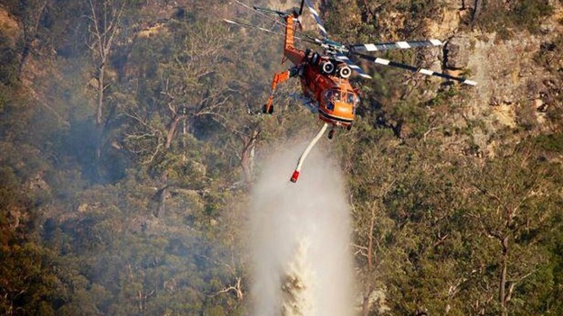 An Air-Crane Helitanker dumps water on a fire near Marulan, which is located around 87 miles from south west Sydney.