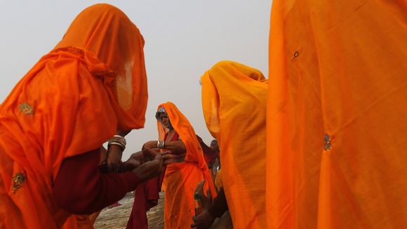 Hindus apply oil on bodies after taking holy dip in the River Ganges ahead of the festival