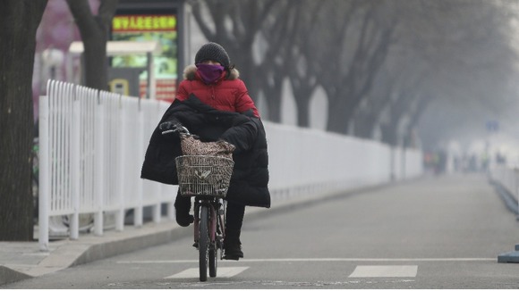 Many people wear face masks or cover their mouths with scarves to protect themselves.