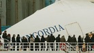Relatives of victims stand on a ferry in front of the capsized cruise liner Costa Concordia outside Giglio harbour