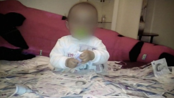 A photo seized by police of a baby surrounded by cash