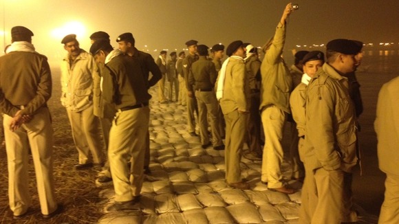 Police line the river and take pictures of the crowds