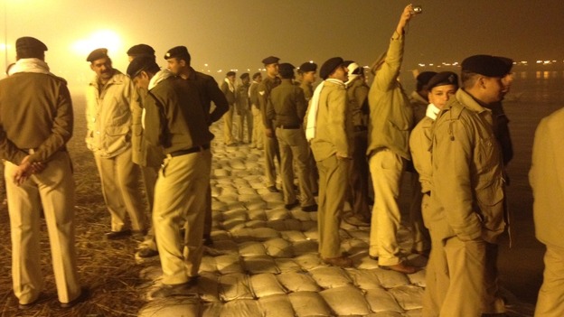 Police line the river and take pictures of the crowds