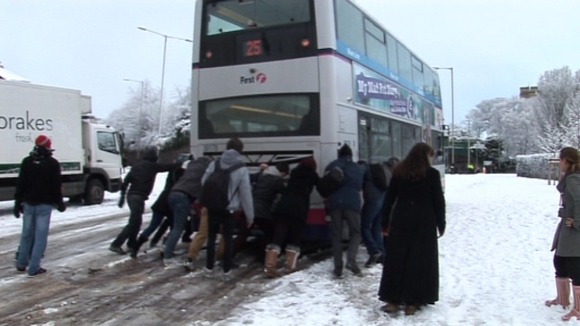 People help push a bus up Market Avenue in Norwich