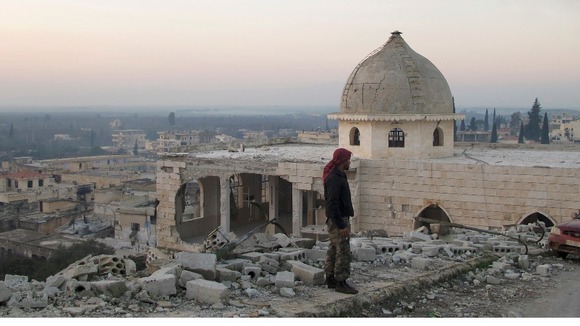 A Free Syrian Army fighter inspects a damaged mosque in Harem town, Idlib Governorate
