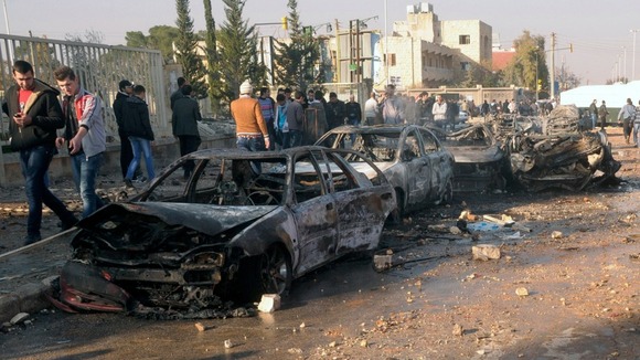 Damaged cars are seen at the site where two explosions rocked the University of Aleppo