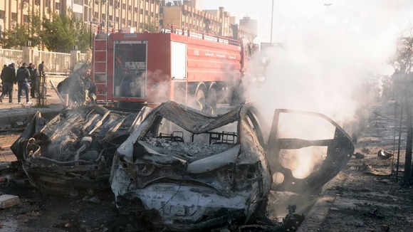 Damaged cars are seen at the site where two explosions rocked the University of Aleppo in Syria's second largest city