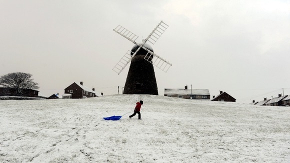 A child walking with a sledge at Whitburn Windmill near Sunderland.