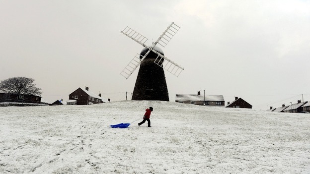 A child walking with a sledge at Whitburn Windmill near Sunderland.