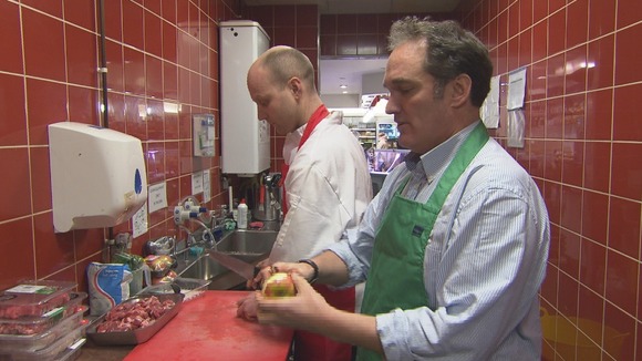 2 men prepare food in a kitchen