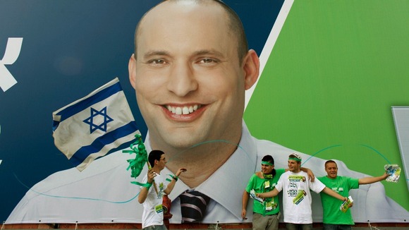 Supporters of the the far-right Jewish Home party stand in front of a campaign poster depicting Naftali Bennett in Tel Aviv.