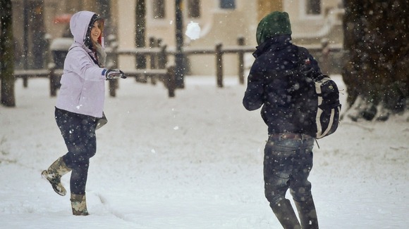 People have a snow ball fight in Bristol as heavy snow disrupts travel and services in the city.