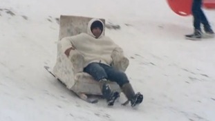 A man speeds down a Norfolk hill in his toboggan armchair.