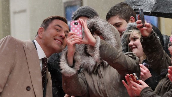 David Walliams poses for pictures with waiting fans.