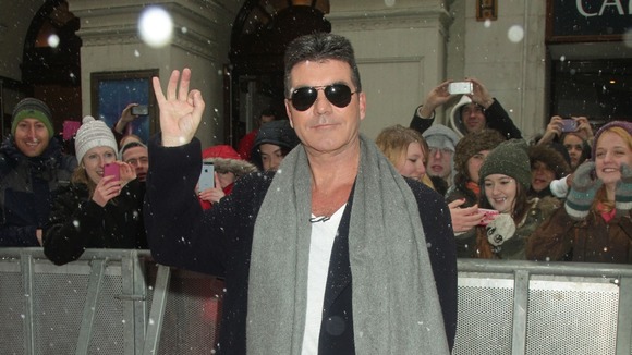 Simon Cowell waves for the cameras in London.