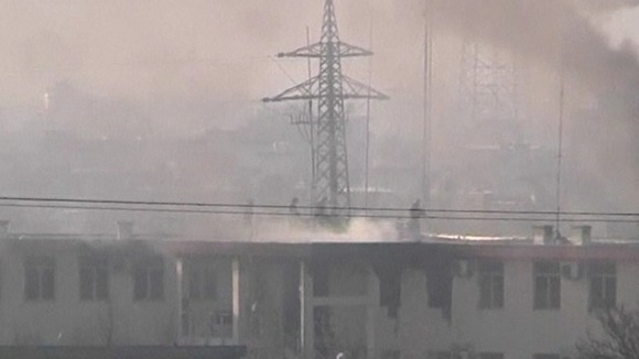 Afghan security forces run on the roof of the Kabul traffic police headquarters