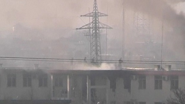 Afghan security forces run on the roof of the Kabul traffic police headquarters 