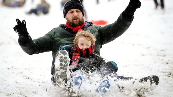 James Sledge and his son Buster have fun sledging in Victoria Park, Totterdown, Bristol