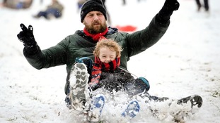 James Sledge and his son Buster have fun sledging in Victoria Park, Totterdown, Bristol