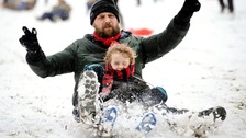 James Sledge and his son Buster have fun sledging in Victoria Park, Totterdown, Bristol