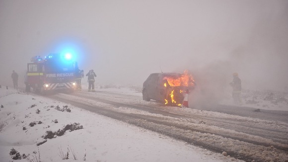 Fire fighters attend the car fire in Devon
