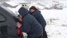 Carers pushing car out of snow