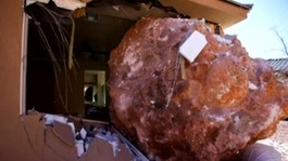 Boulder comes to rest through the bedroom wall