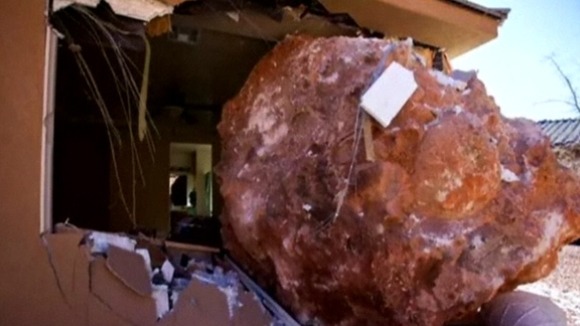 Boulder comes to rest through the bedroom wall