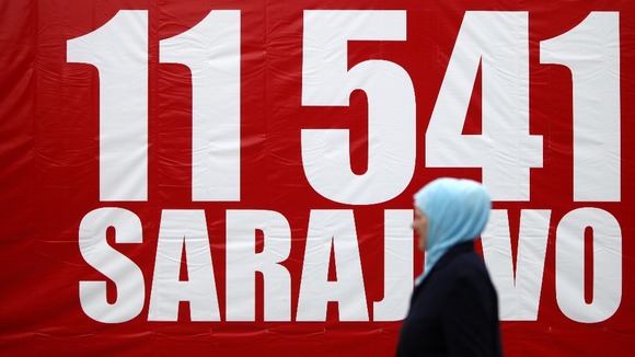 A woman walks near a banner with the number 11,541, to symbolise the red chairs