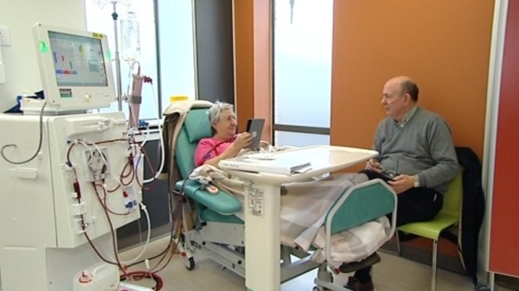 Woman in hospital bed talking to visitor