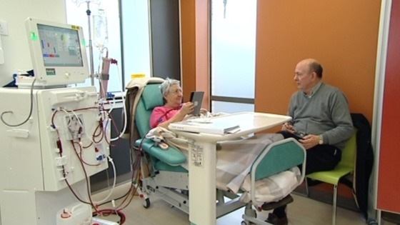 Woman in hospital bed talking to visitor