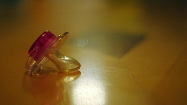 Police are investigating after a four month baby was found with a dummy taped to his face.