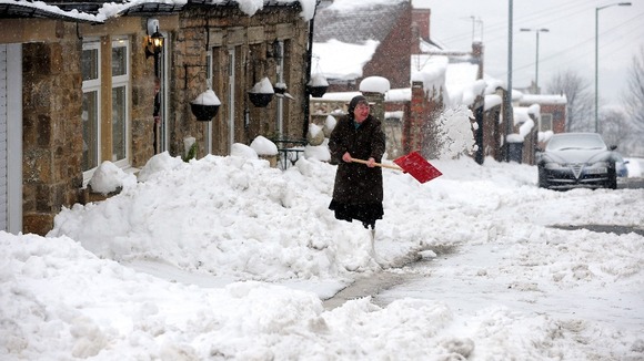A woman digs her way out of snow in Tanfield County, Durham