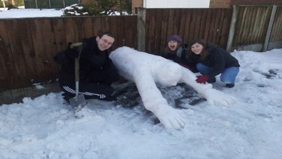 Snowman diving through the garden fence