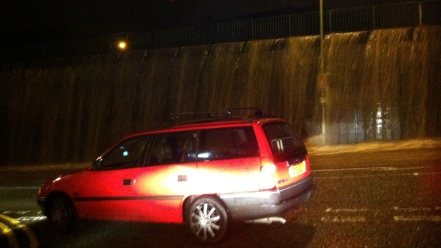 Car drives past floods