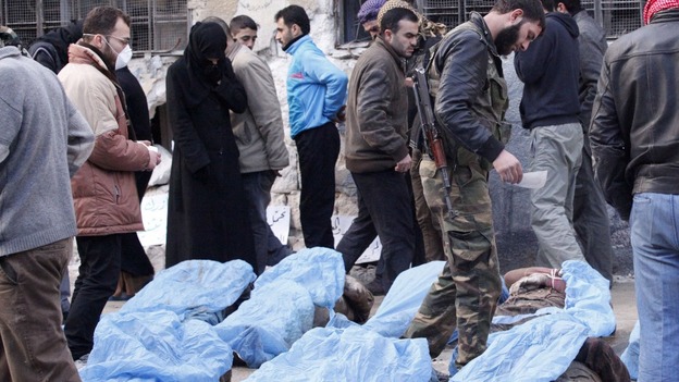 A woman is seen crying as relatives attempt to identify bodies found dead with their hands bound in Aleppo