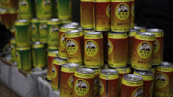 The orange and green cans carry a caricature of Mr Guangbiao
