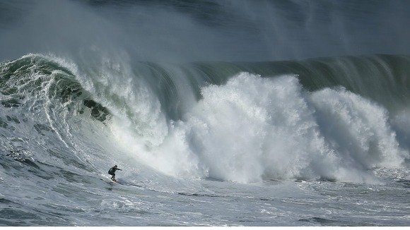 Portuguese big-wave surfer Hugo Vau drops in on a large wave at Praia do Norte in Nazare