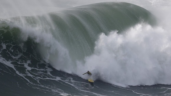 Big-wave surfer Garrett McNamara drops in on a large wave at Praia do Norte in Nazare