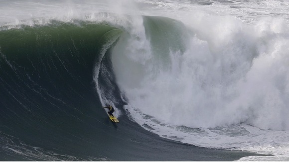 Big-wave surfer Garrett McNamara drops in on a large wave at Praia do Norte in Nazare
