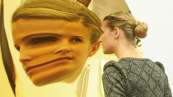 A woman looks into an Amish Kapoor's Untitled sculpture
