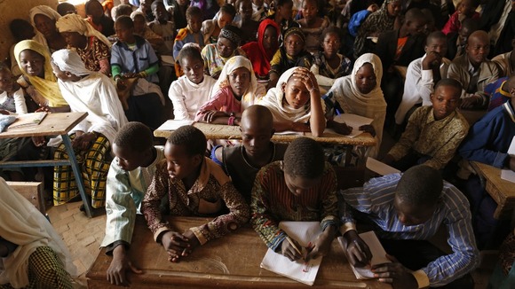 Children listen to a school teacher after the reopening of Mahamane Fondogoumo school in the centre of Timbuktu