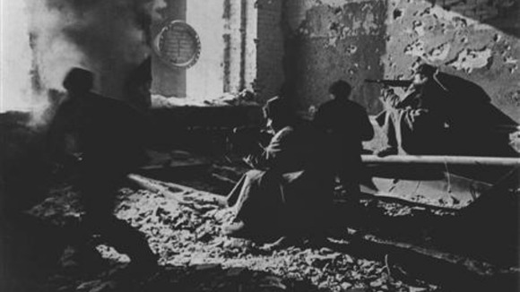 Red Army soldiers fire from a ruined building as they fight against Nazi troops.
