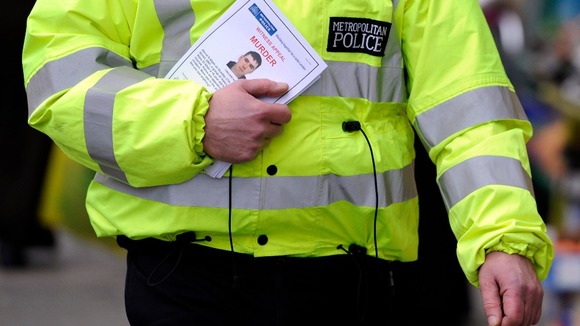 A policeman distributes witness appeal leaflet