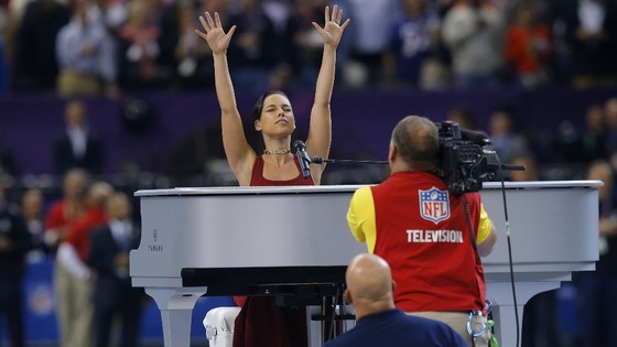 Singer Alicia Keys acknowledges the crowd while performing America's National Anthem before the start of the game.