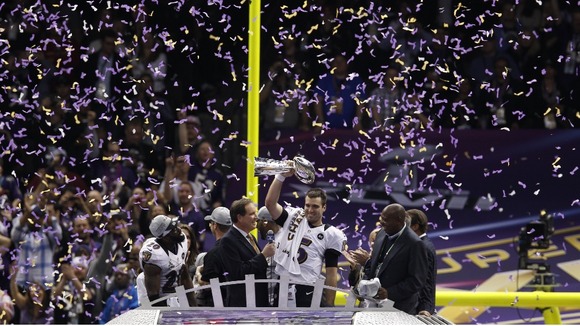 Baltimore Ravens quarterback Joe Flacco raises the Vince Lombardi Trophy.