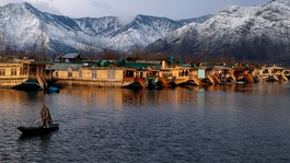 A Kashmiri man rows his boat in the waters of the Dal Lake on a cold winter evening in Srinagar